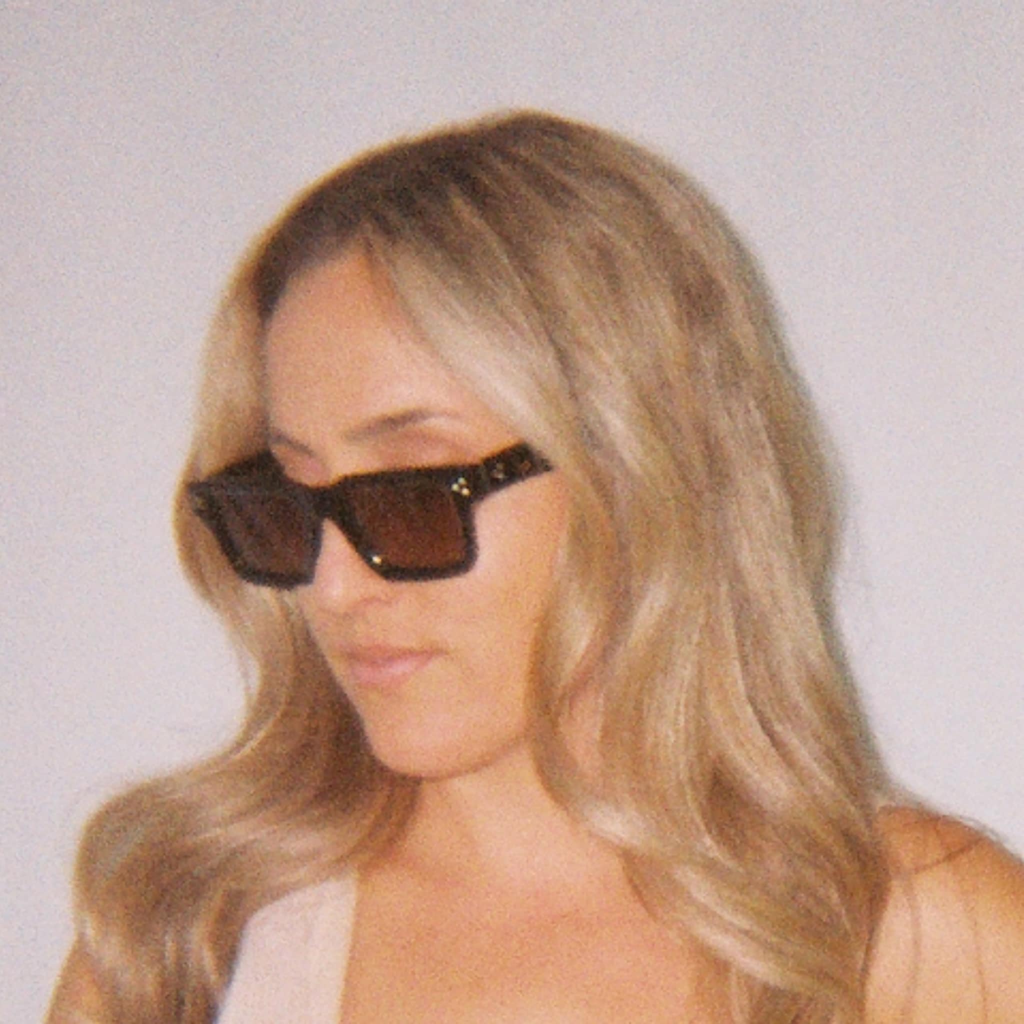 Female model wearing Soul California Eyewear Elaris sunglasses crafted from ebony acetate with brown gradient polarized lenses.