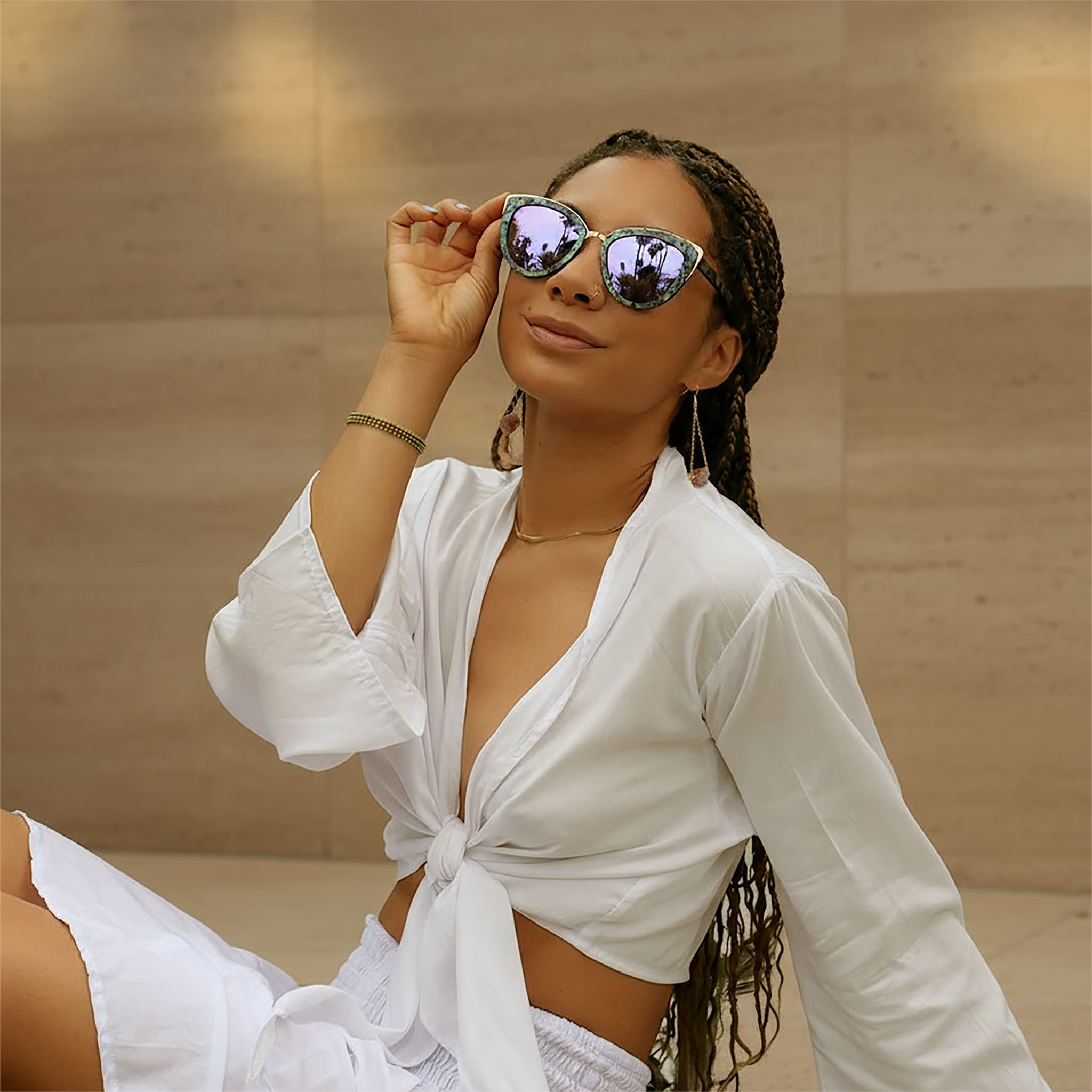 Model wearing Soul California Eyewear Hermosa Beach Lilac sunglasses crafted from ebony wood and New Zealand abalone paua shell with lilac mirrored polarized UV400 lenses.