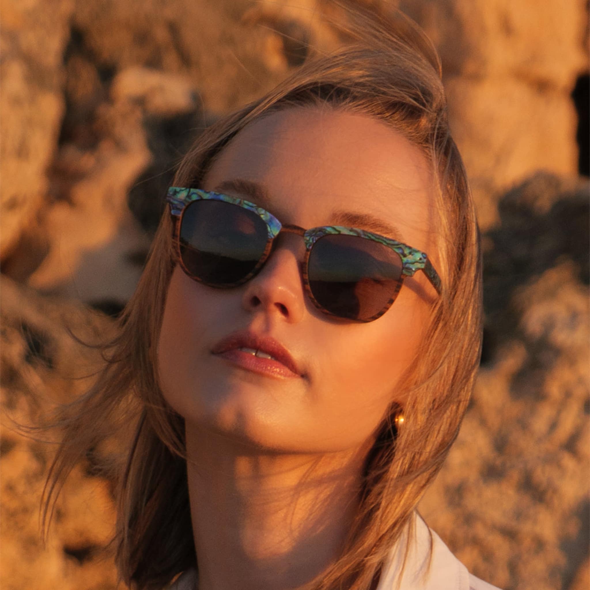 Female model wearing Soul California Eyewear Pebble Beach Dusk sunglasses crafted from zebra wood and genuine abalone shell.