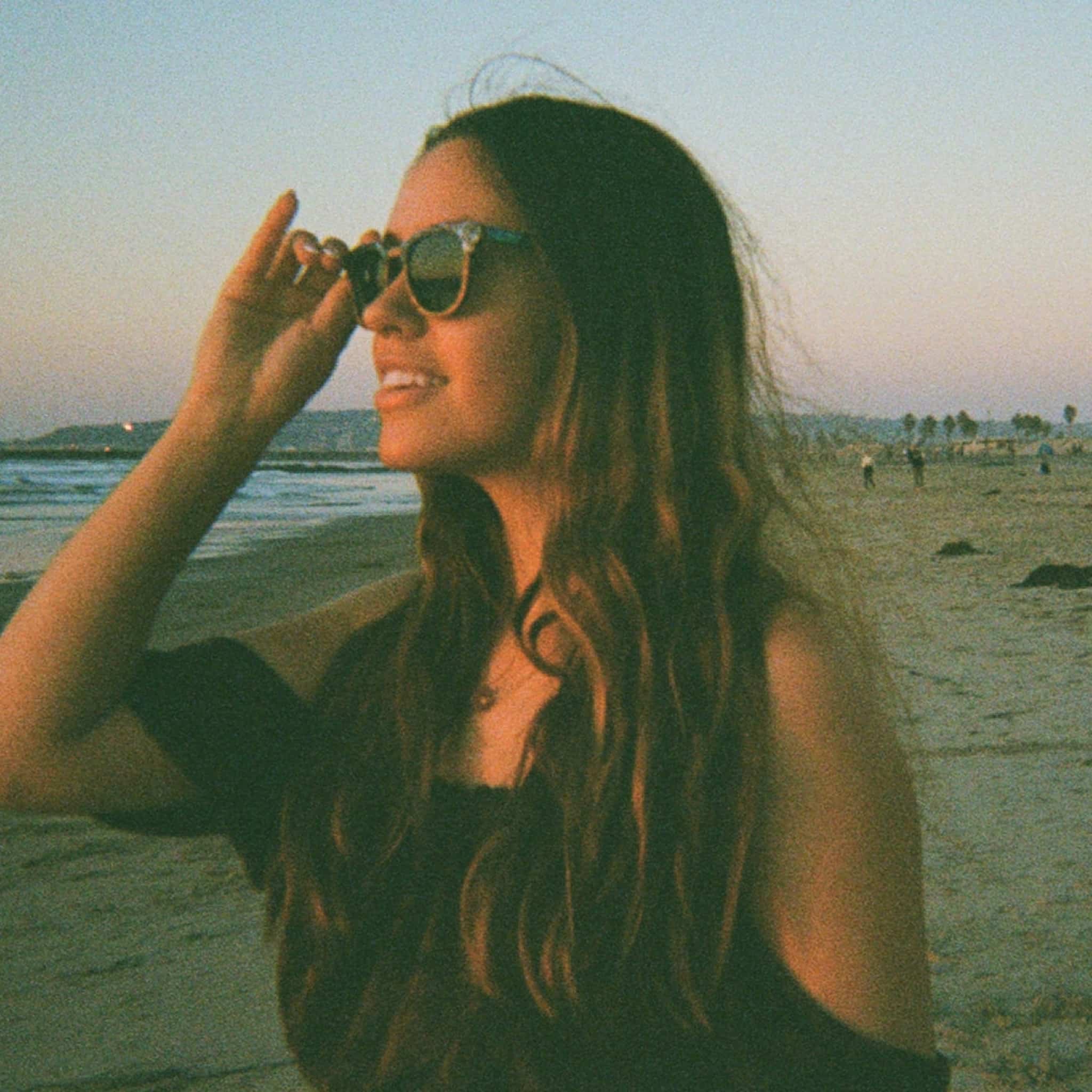 Side profile of female model wearing Soul California Eyewear Pebble Beach Dusk sunglasses featuring zebra wood temples with abalone shell inlay.