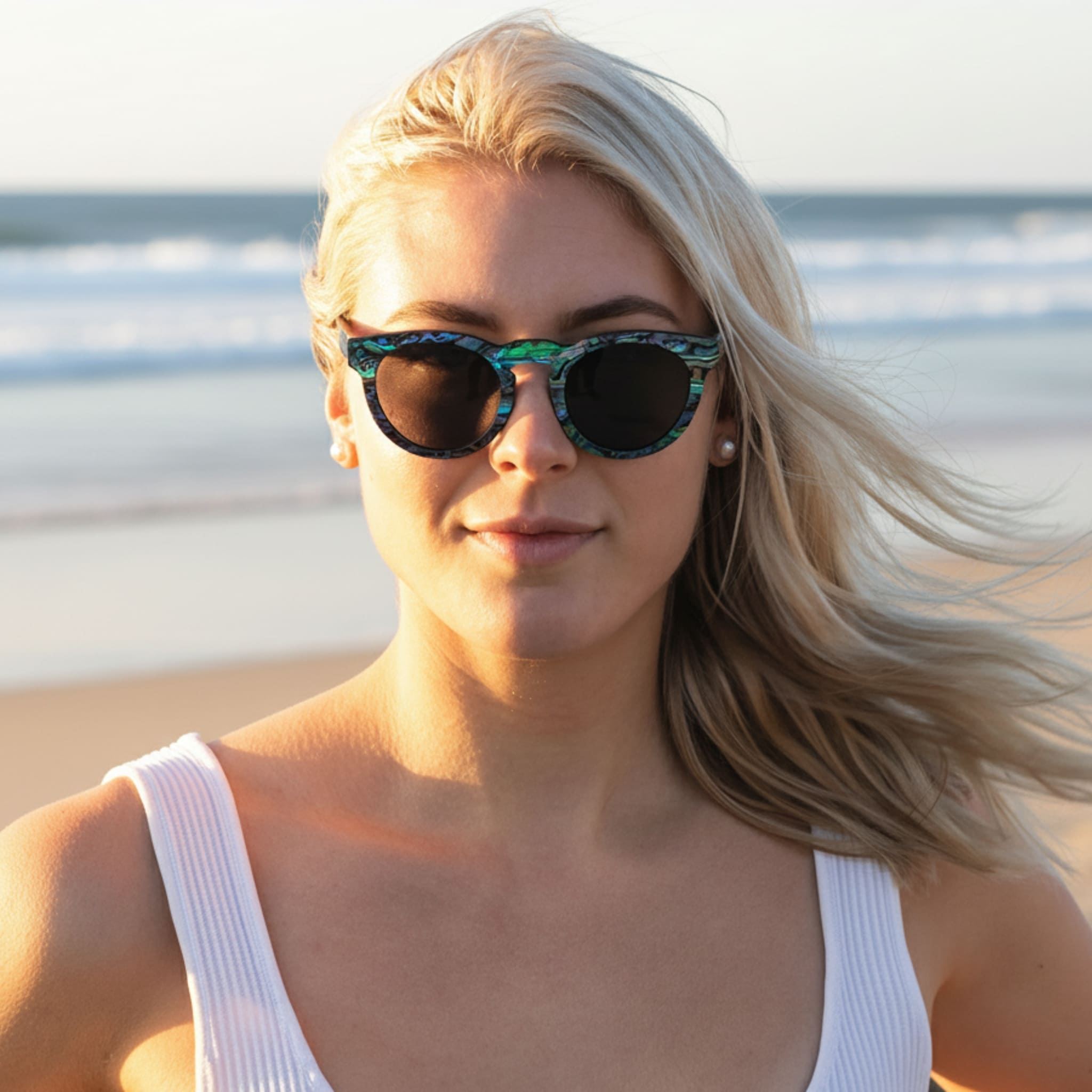 Model wearing Soul California Eyewear Pfeiffer Beach Dusk sunglasses crafted from Zebra Wood and New Zealand Abalone Paua Shell with polarized light black lenses.