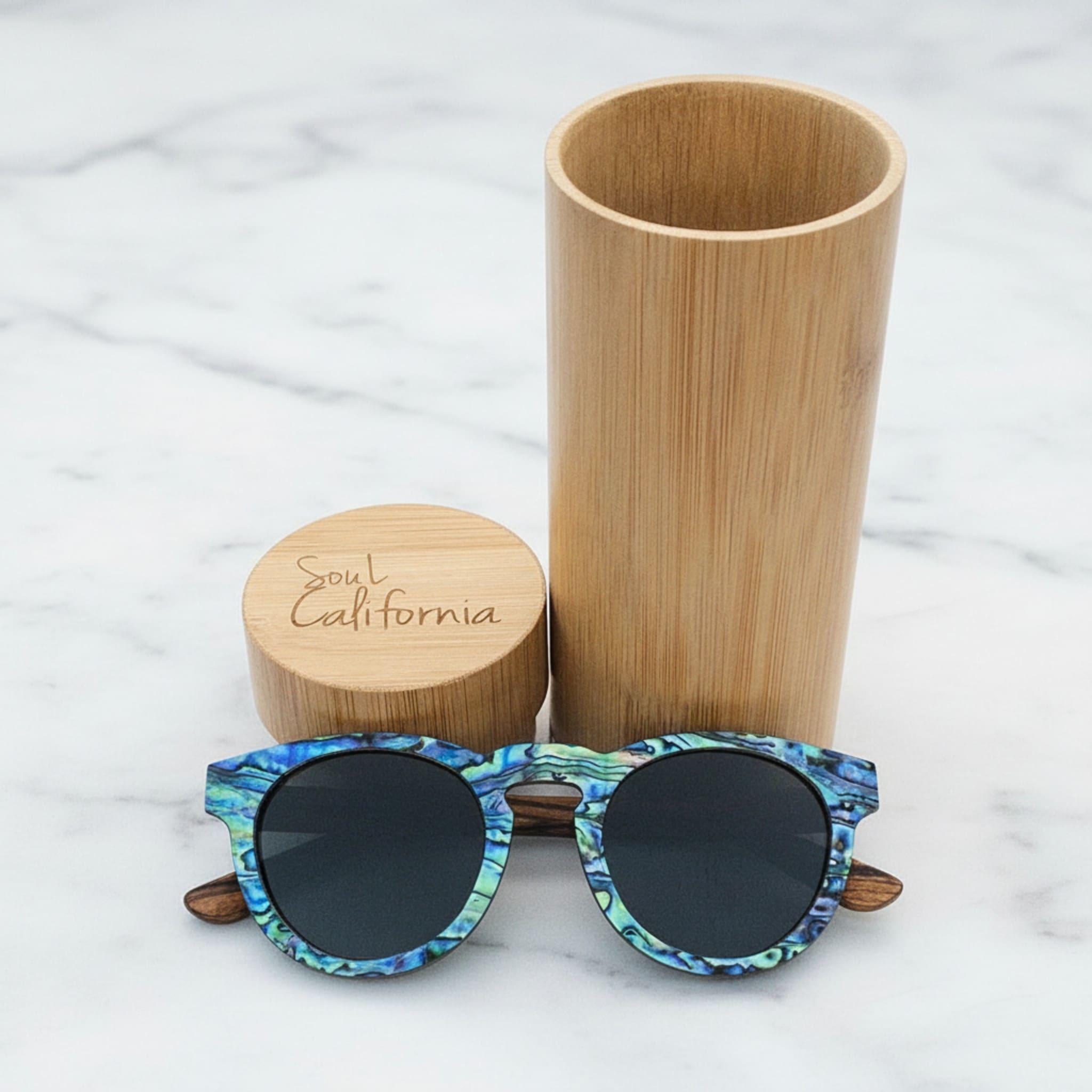 Soul California Eyewear Pfeiffer Beach Dusk sunglasses front view with case, featuring Zebra Wood and New Zealand Abalone Paua Shell with polarized light black lenses.