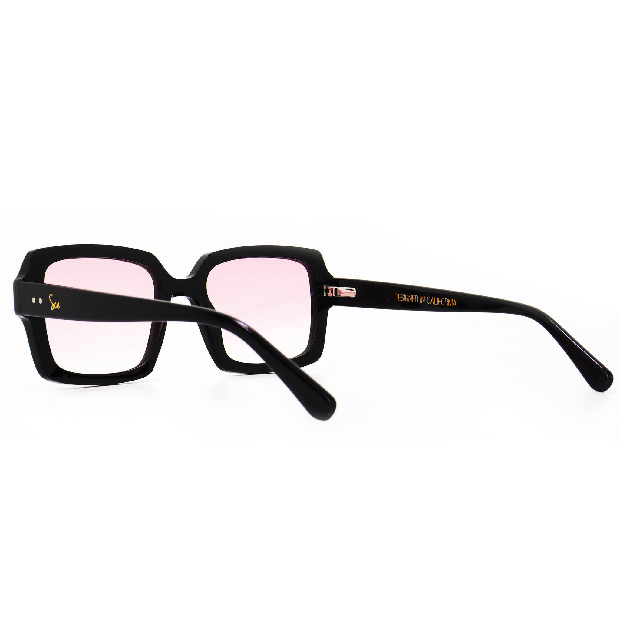 Angled top view of Soul California Eyewear Rosara sunglasses highlighting the sculpted black acetate frame with pink gradient lenses.